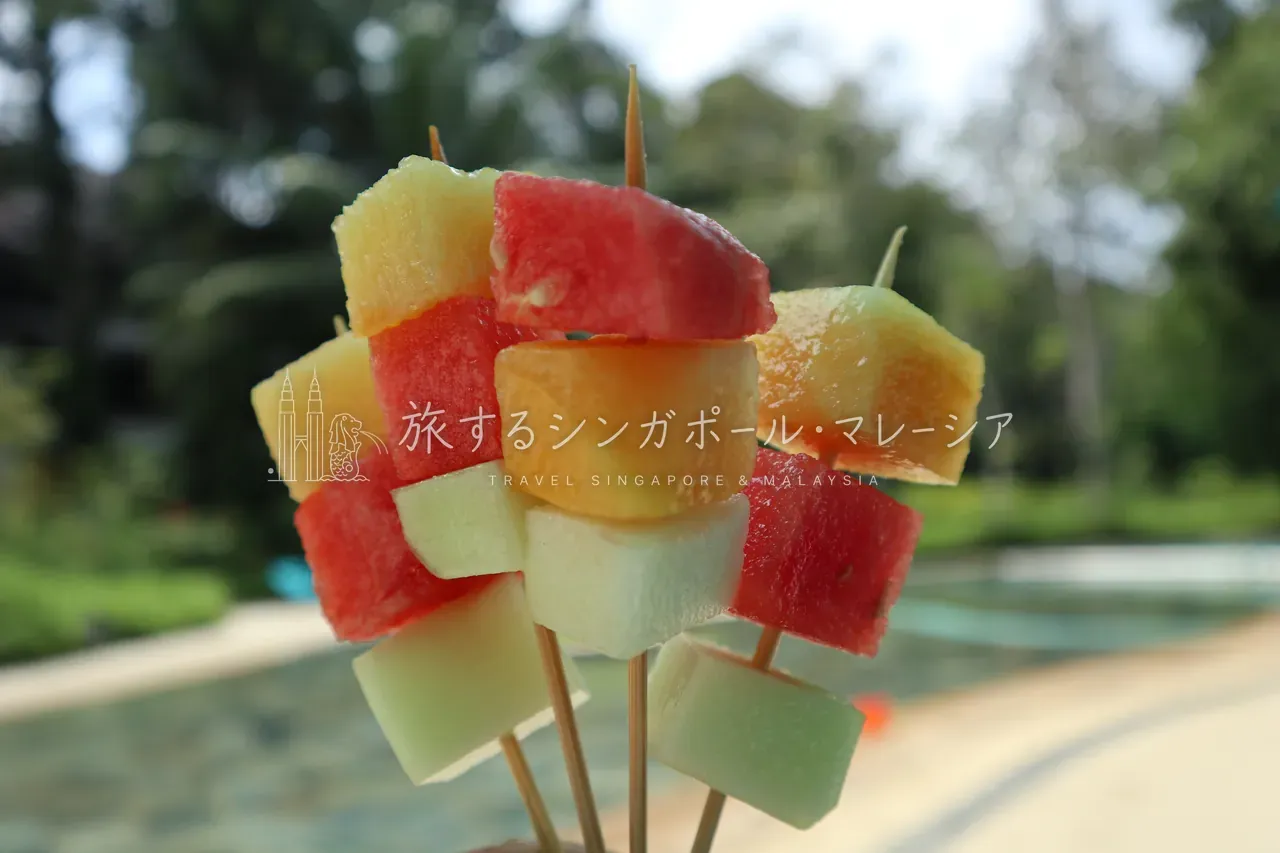 左：レストラン側から見たプール全景。右：時折フルーツなどの食べ物サービスも。こういうの、うれしいですよね。