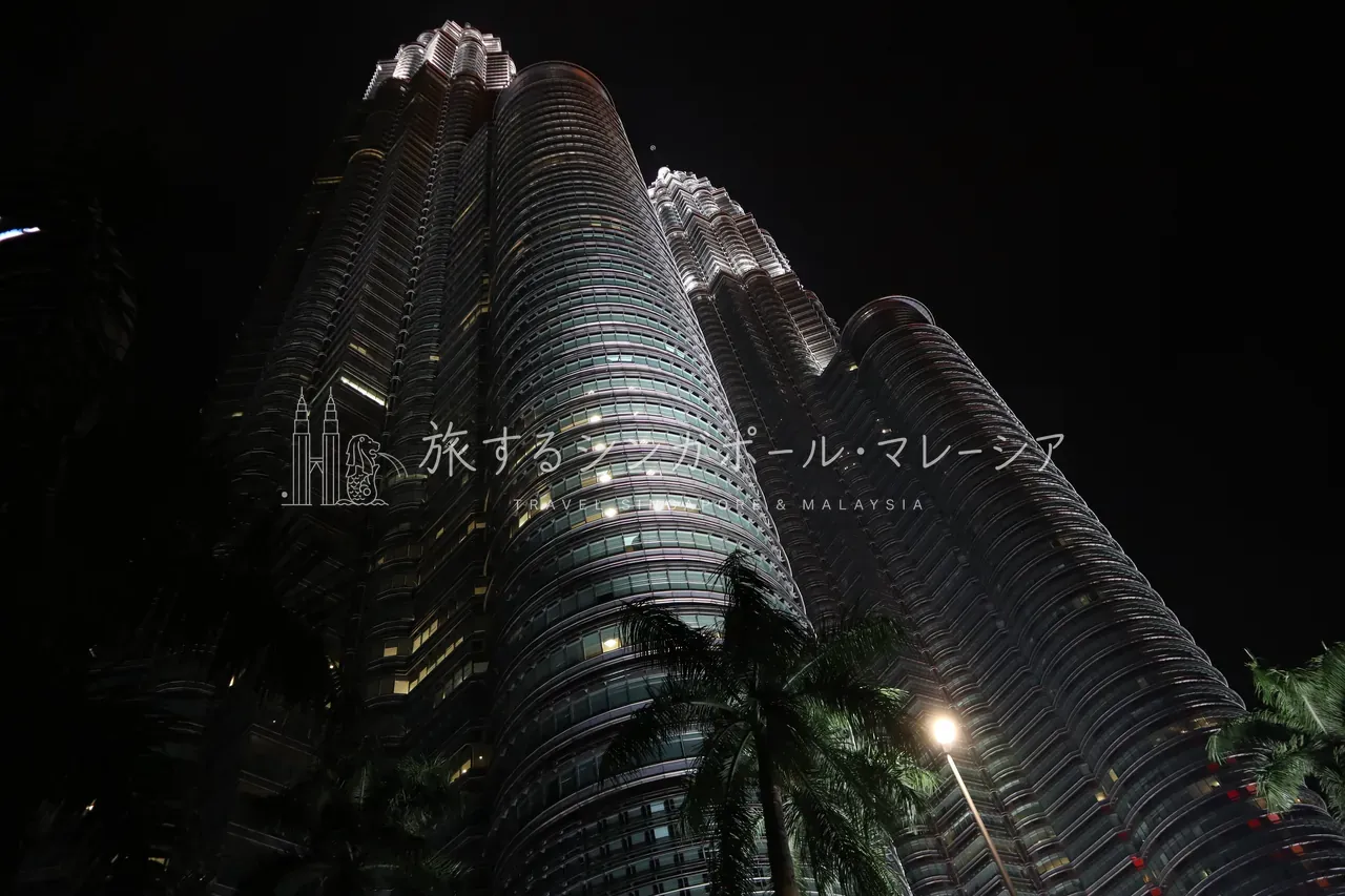 左：真下から見上げた夜のツインタワー。鋼鉄の双塔が闇に光る様子は、昼とは完全に別物の表情です。右：タワーの目の前のWクアラルンプールに泊まれば、客室の窓からこの夜景が。タワービューのホテルもかなりアリです。
