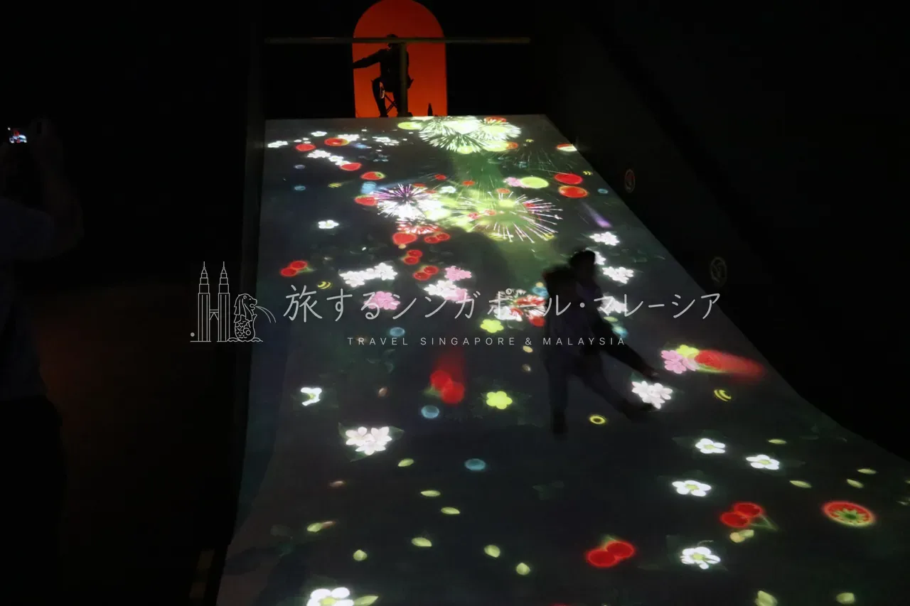 左:滑ると花火が上がる滑り台。右:小物を動かすと映像が変わる丸テーブル。どれも“参加して完成する”作品です。