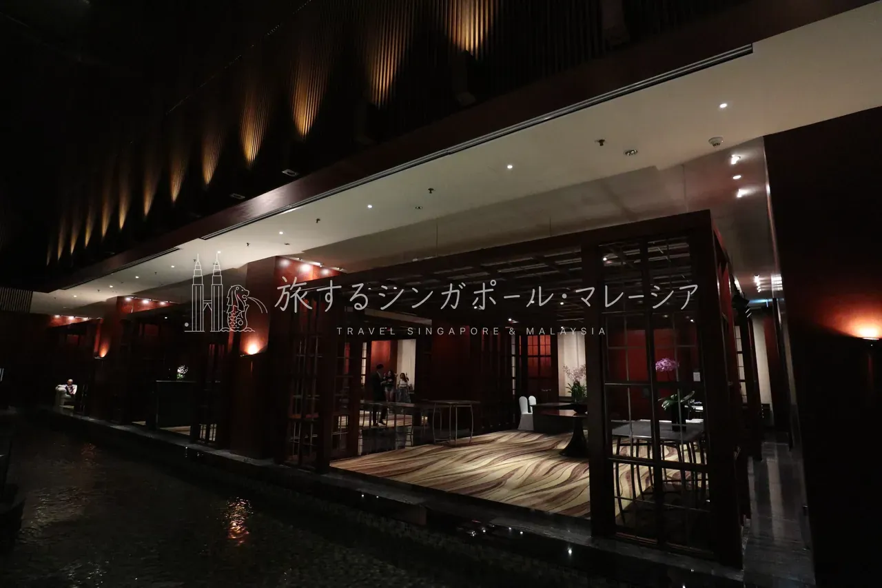 左：落ち着いた雰囲気のロビー。右：ロビー手前には水が張られ、雰囲気抜群。右奥のエレベーターで上階へ。