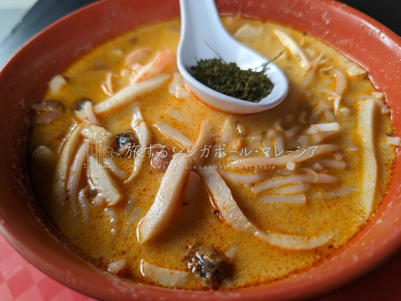 328 Katong Laksa。エビとハマグリの橙色スープに、短く切った麺。レンゲで一気に。
